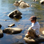 A student watches the river for new ecosystems. 